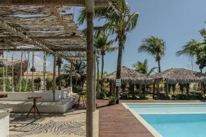 a resort with a swimming pool and palm trees at Zebra Boutique Hotel in Beberibe