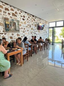 a group of people sitting at tables in a restaurant at Vila Llaka in Himare
