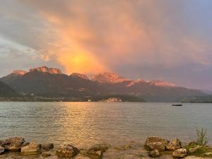 a rainbow over a lake with mountains in the background at Appartement 55 m2 proche de la plage in Sévrier