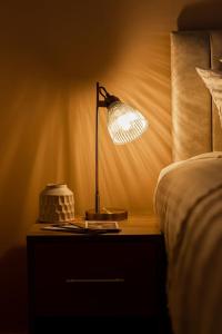 a lamp on a night stand next to a bed at Super Central - Quiet - 2 Bedroom Cottage in Shrewsbury +51 photos