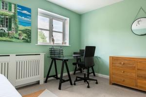 a bedroom with green walls and a desk and chairs at 4 Bedroom Town House with Parking in Shrewsbury