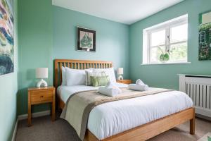 a bedroom with a large bed with blue walls at 4 Bedroom Town House with Parking in Shrewsbury
