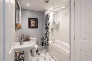 a white bathroom with a sink and a tub and a toilet at 4 Bedroom Town House with Parking in Shrewsbury