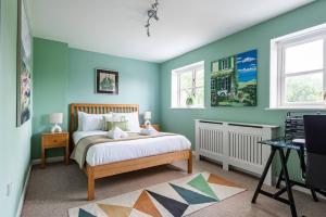 a bedroom with blue walls and a bed and a desk at 4 Bedroom Town House with Parking in Shrewsbury