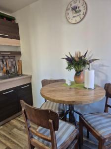 a kitchen with a table with a clock on the wall at Amanda's apartment in Kuldīga