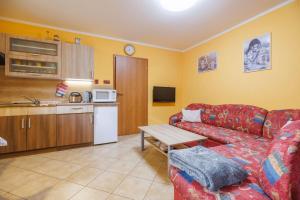 a living room with a red couch and a kitchen at Pastvinka in Pastviny