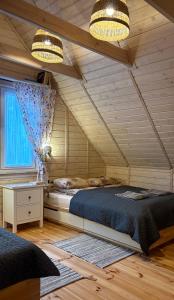 a bedroom with a large bed and two lights at Siedlisko Konradówka in Olecko +64 photos