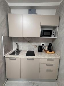 a white kitchen with a sink and a microwave at Romantic Suite Genova in Genoa