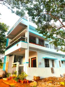 a blue and white building with plants in front of it at Keshu Home Stay Hampi in Hospet