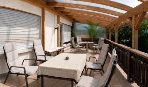 eine Terrasse mit Tisch und Stühlen auf einem Deck in der Unterkunft Casa Sonora in Lichtenfels + 9 Fotos