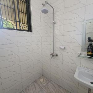 a white bathroom with a shower and a sink at Mary homestays in Dar es Salaam +31 photos