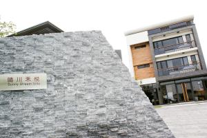 a building with a stone wall with a sign on it at Sunny Stream B & B in Wujie