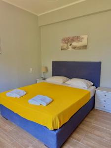 a bedroom with a large bed with a yellow blanket at Captain Michalis house in Parga