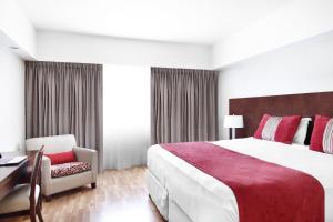 una camera d'albergo con un grande letto e una scrivania di Cyan Hotel de Las Americas a Buenos Aires