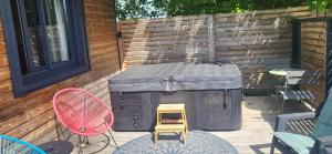 a patio with a grill and a chair and a table at Ty KamBreiz in La Fresnais