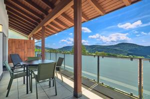 a balcony with a table and chairs and a view of the water at Annies Bergwelt Haus Waldherz in Bodenmais