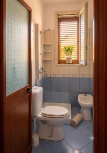 a bathroom with a toilet and a sink and a window at Apartments Vila Cala in Durrës +56 photos