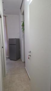 a white room with a door and a refrigerator at Appartamenti Del Pesco in Trapani