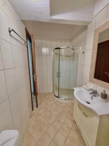 a bathroom with a shower and a toilet and a sink at Captain Michalis house in Parga +13 photos