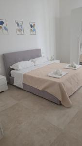 a bedroom with a large bed with two towels on it at Appartamenti Del Pesco in Trapani