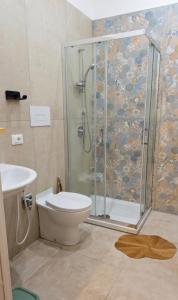 a bathroom with a shower and a toilet and a sink at Appartamenti Del Pesco in Trapani
