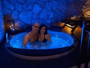 a man and a woman in a bath tub at SPA SUITE SICILIA - Suite con Spa privata ad uso esclusivo Jacuzzi Sauna Hammam in Rosolini