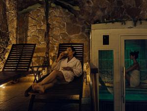 a man sitting in a chair drinking a beverage at SPA SUITE SICILIA - Suite con Spa privata ad uso esclusivo Jacuzzi Sauna Hammam in Rosolini