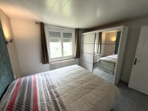 a small bedroom with a bed and a window at Au cœur de Maîche in Maîche