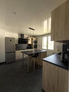 a kitchen with a table and a refrigerator at Au cœur de Maîche in Maîche
