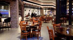 a dining room with wooden tables and chairs at Bally's Baton Rouge Hotel in Baton Rouge