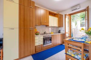 a kitchen with wooden cabinets and a refrigerator at Happy Guest Apartments - Lake Panorama & Pool in Riva di Solto