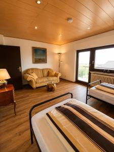 a living room with two beds and a couch at Ferienwohnung Maison Maurus nahe Idar-Oberstein in Mörschied