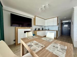 a kitchen with a table and a dining room at Apartment & Room MARINA BORKI - Apartamenty RÓŻA WIATRÓW in Augustów