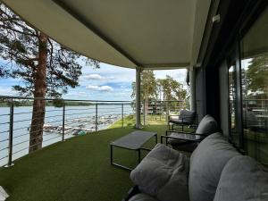 a living room with a couch and a view of the water at Apartment & Room MARINA BORKI - Apartamenty RÓŻA WIATRÓW in Augustów