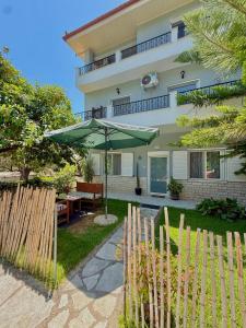 a patio with a table and an umbrella in front of a house at Captain Michalis house in Parga