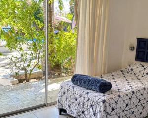a bedroom with a bed and a large window at Hotel Calafia in La Paz