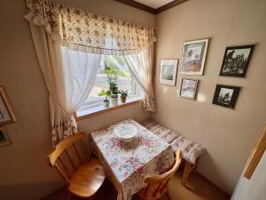a table and chairs in a room with a window at Lofoten Light - Private Rooms with Shared Facilities in Gravdal