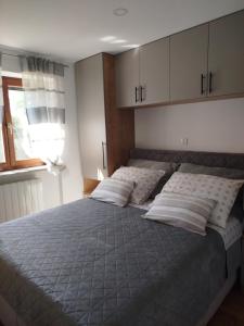 a bedroom with a large bed with pillows and a window at Apartment Elio 1606 in Labin