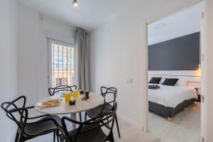 a room with a table and chairs and a bed at Trendy Homes Almeria Center in Almería