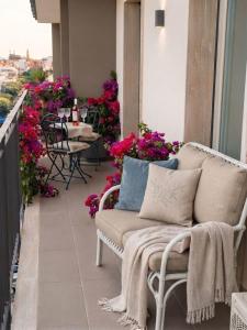 a balcony with a chair and tables and flowers at Simohouse Lecce - Executive Suite Apartment 140mq - 2 Bathrooms in Lecce