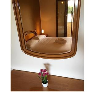 uno specchio a parete con un letto in camera di Residence Cà Mazzini a San Giorgio Di Mantova