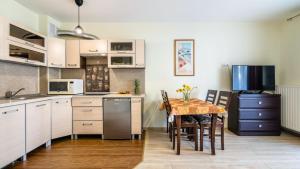 a kitchen with a table and a dining room at Osiedle Bursztynowe in Jantar