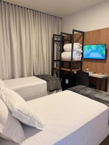 a hotel room with two beds and a tv at Rio Jordao Hotel in Siderópolis