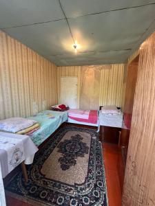 a room with two beds and a rug at Дом отдыха in Bosteri