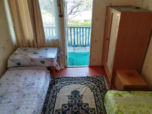 a small room with a bed and a window at Дом отдыха in Bosteri