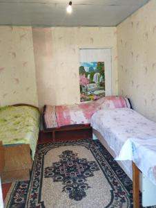 a room with two beds and a rug at Дом отдыха in Bosteri