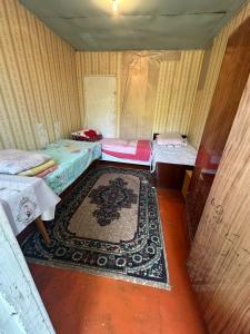 a room with three beds and a rug at Дом отдыха in Bosteri