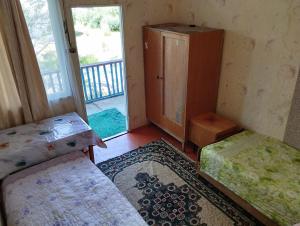 a small room with two beds and a window at Дом отдыха in Bosteri