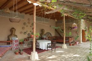 a patio with a table and some statues in a building at TURKMAN's PALACE in Urganch