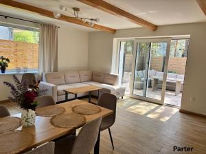a living room with a table and a couch at Trzy Tarasy Swornegacie in Swornegacie